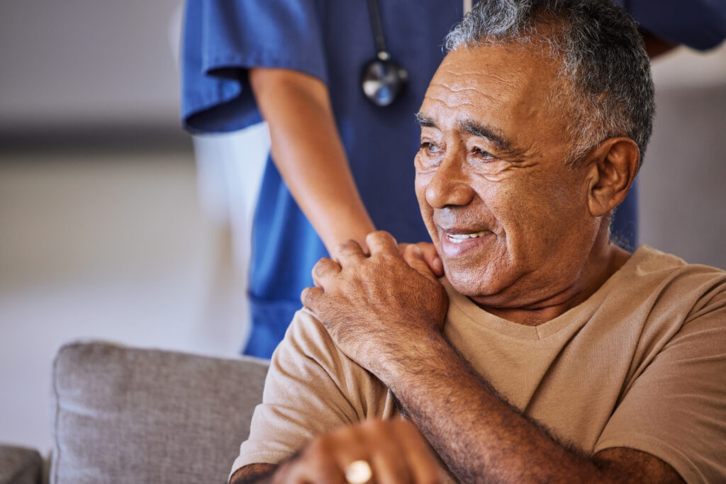 Caregiver holding hand of senior patient.